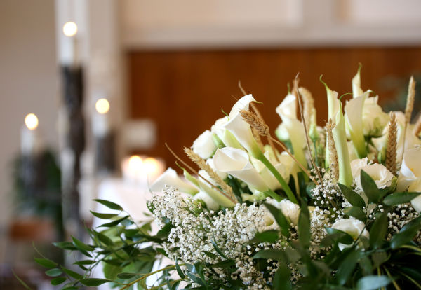 photo of vase of flowers on an altar in the church and the candles on background